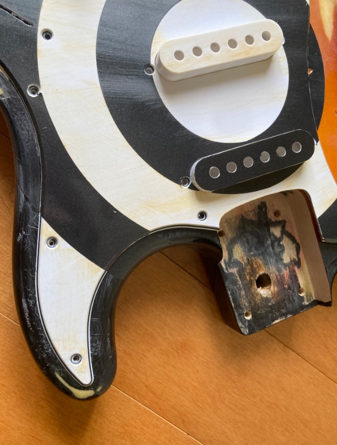 Relicd strat style guitar body, sunburst finish with bullseye graphic.