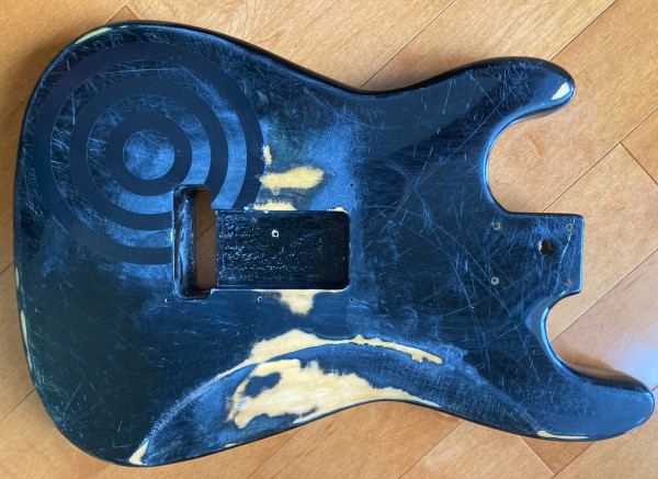 Relicd strat style guitar body, sunburst finish with bullseye graphic.
