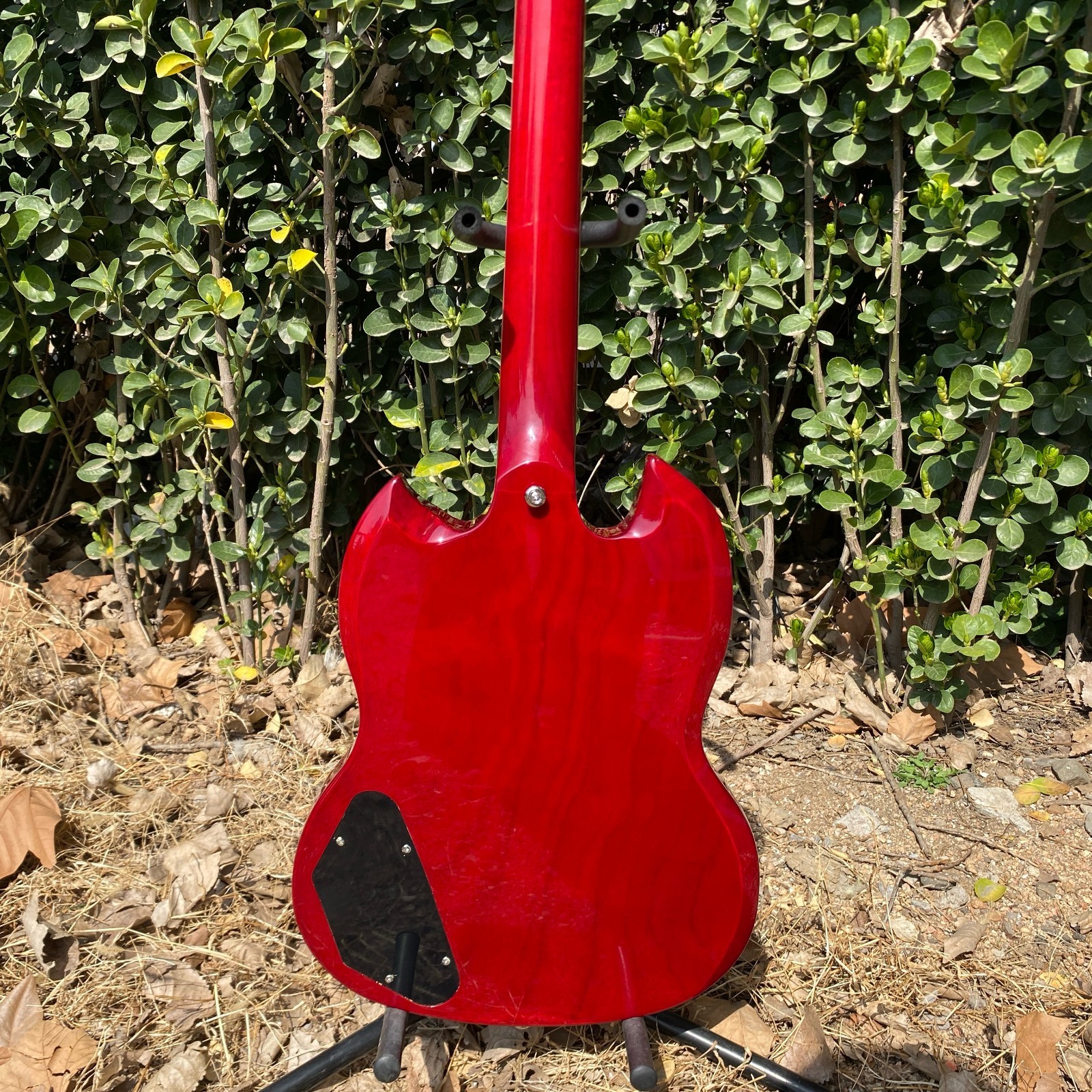 Brand-new, red 6-string electric guitar with mahogany body and chrome hardware.