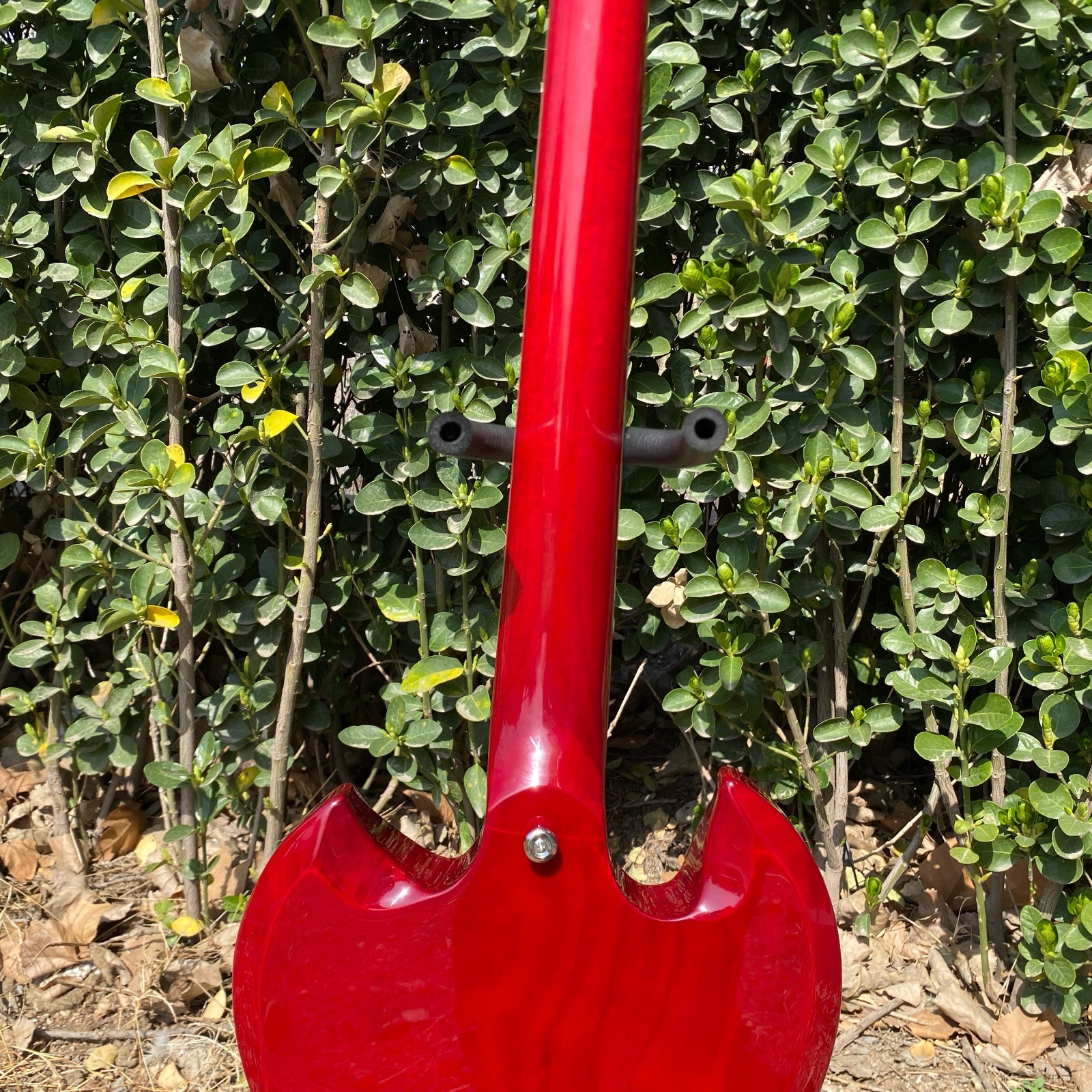 Brand-new, red 6-string electric guitar with mahogany body and chrome hardware.