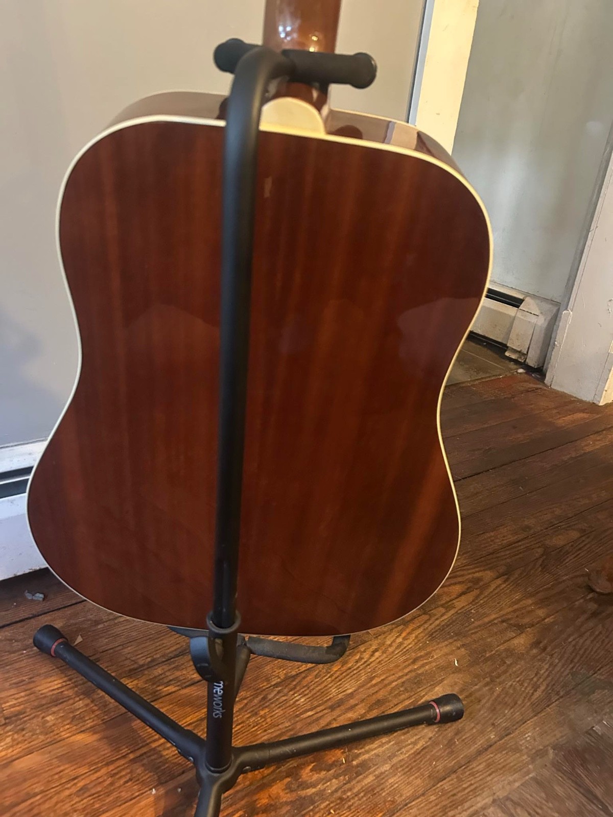 Epiphone Songmaker Dr-100 acoustic guitar with a holding stand.