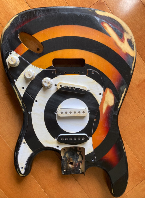 Relicd strat style guitar body, sunburst finish with bullseye graphic.